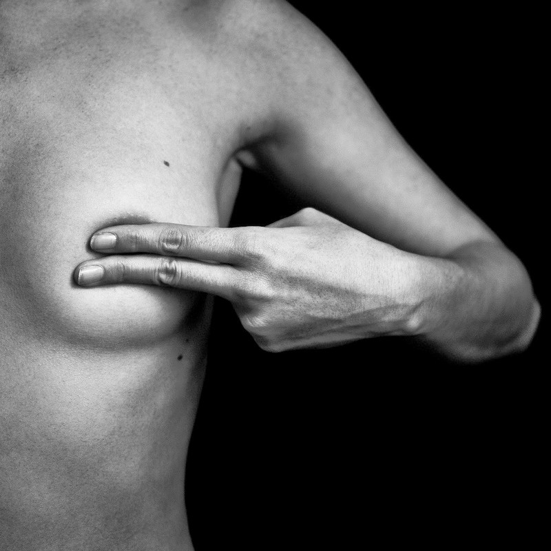 Fotografía en blanco y negro de una una mujer tapándose el pezón de Benoit Courti