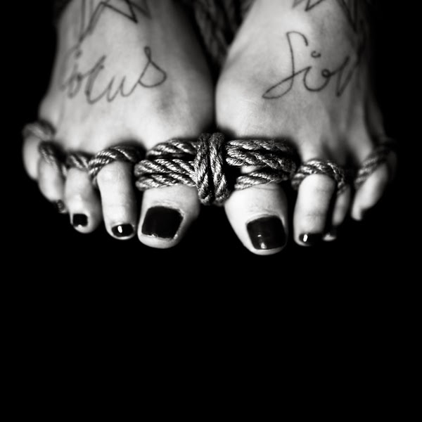 Fotografía en blanco y negro de unos pies amarrados de Benoit Courti