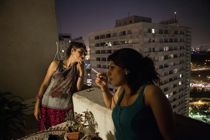 Dos mujeres con la cabeza descubierta, se fuman un cigarrillo y se relajan en su balcón en Irán