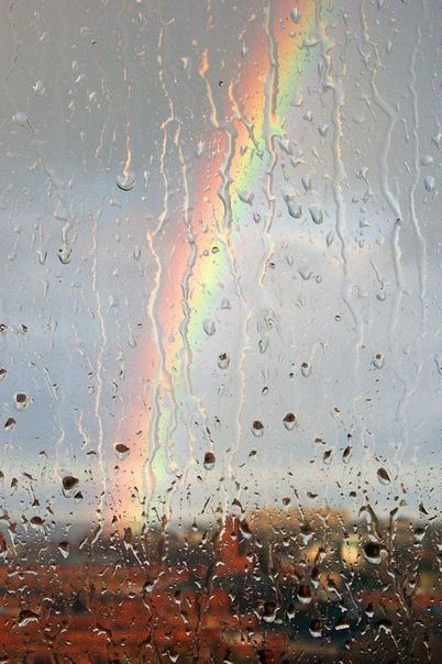 Lluvia en una ventana con el arco iris de fondo
