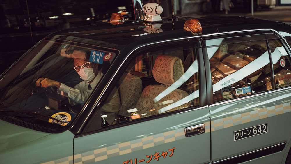 Un taxista en su coche con mascarilla en Tokio.
