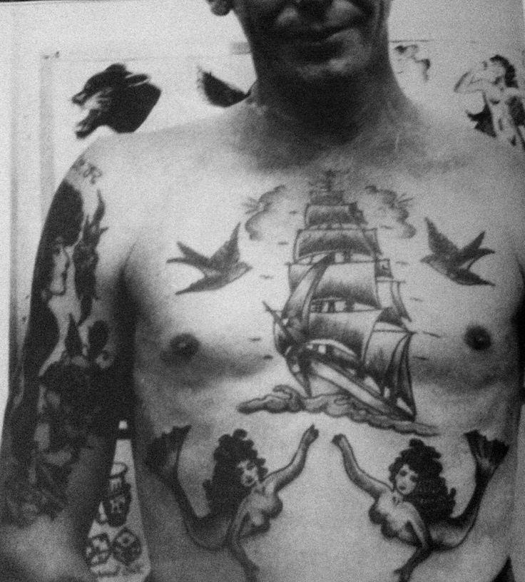 Un hombre con un tatuaje en el pecho de un barco y unas sirenas