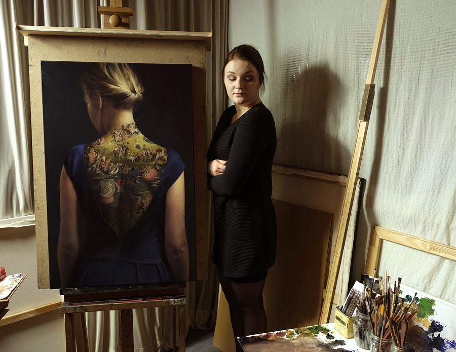 Agnieszka Nienartowicz posando con el cuadro del El jardín de las delicias a modo de tatuaje sobre la espalda de una mujer