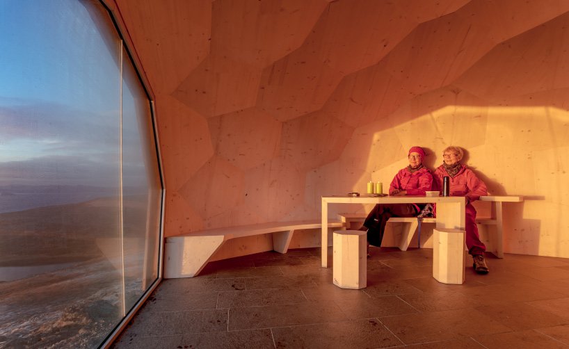 cabaña en el ártico con dos personas observando las vistas