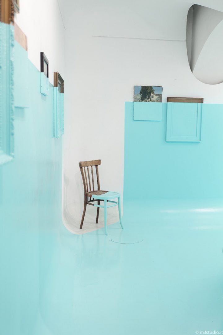 Instalación pintada blanco y azul con silla
