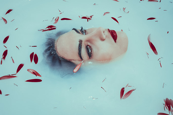 Chica en una bañera solo solo con la cara fuera