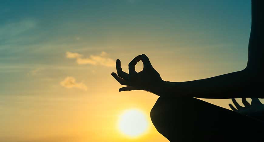 Chica meditando en una puesta de sol