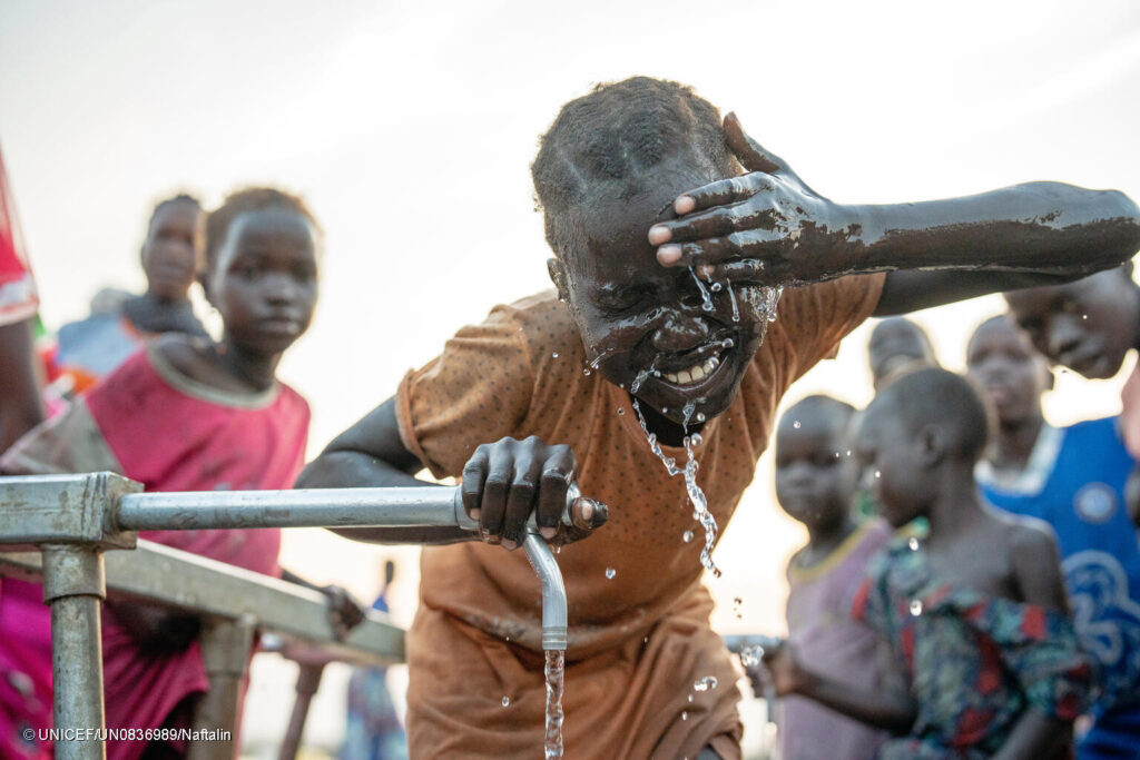 Una niña se lava la cara en unos grifos -instalados con el apoyo de UNICEF-en el campamento de Bieh para personas desplazadas internamente en Bentiu, estado de Unity, Sudán del Sur.