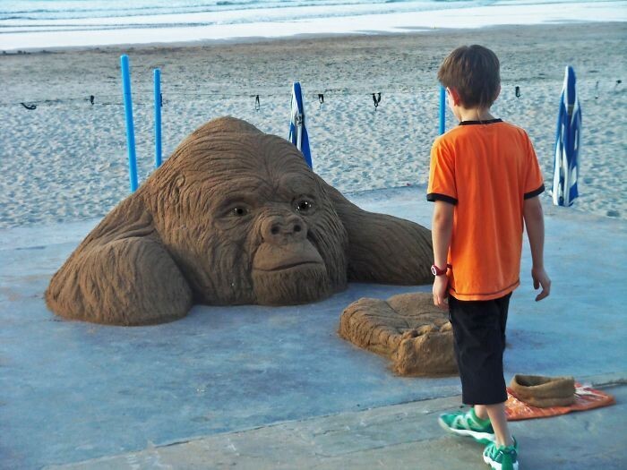 niño observando escultura arena gorila andoni bastarrika