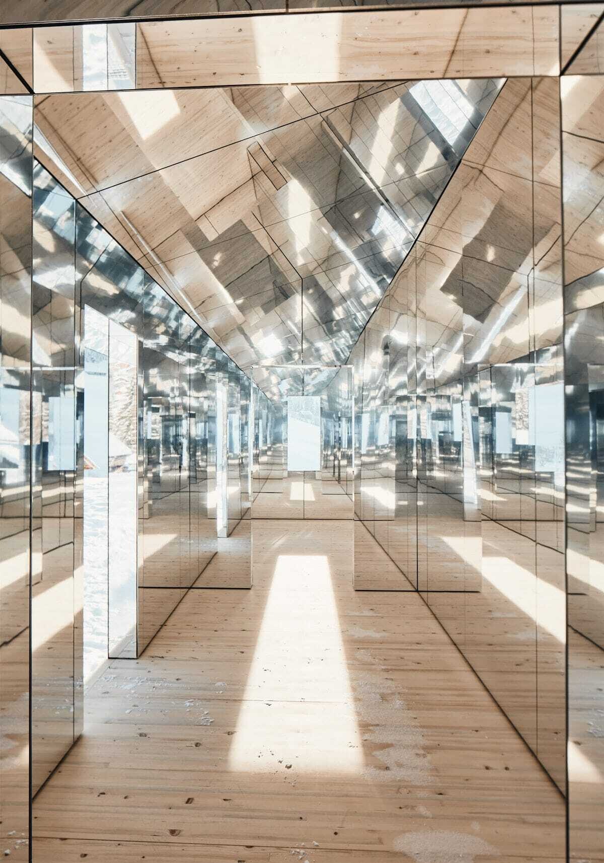 el interior de una casa hecha de espejos refleja su entorno externo e interno