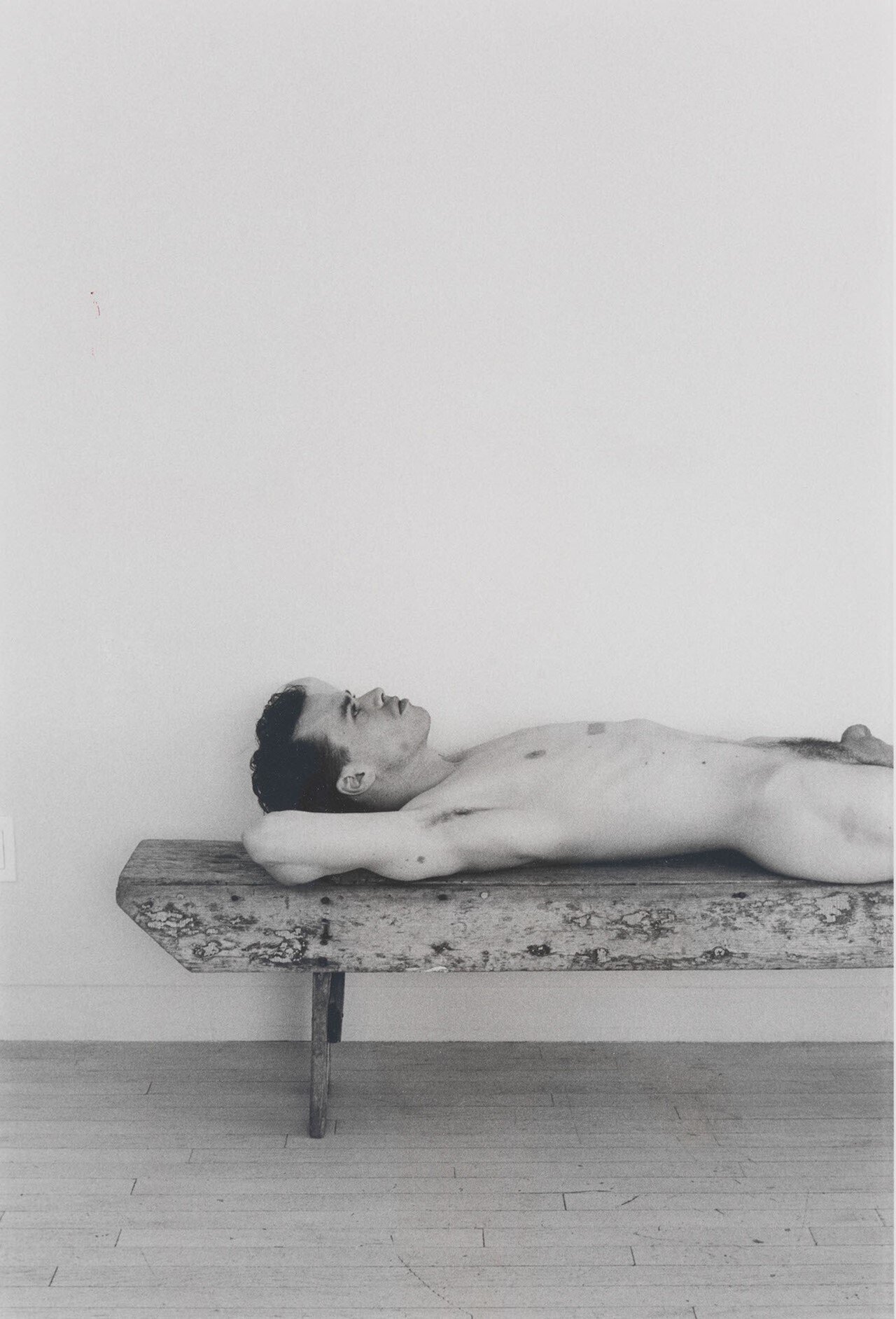 Fotografía en blanco y negro de un chico pensativo tumbado boca arriba