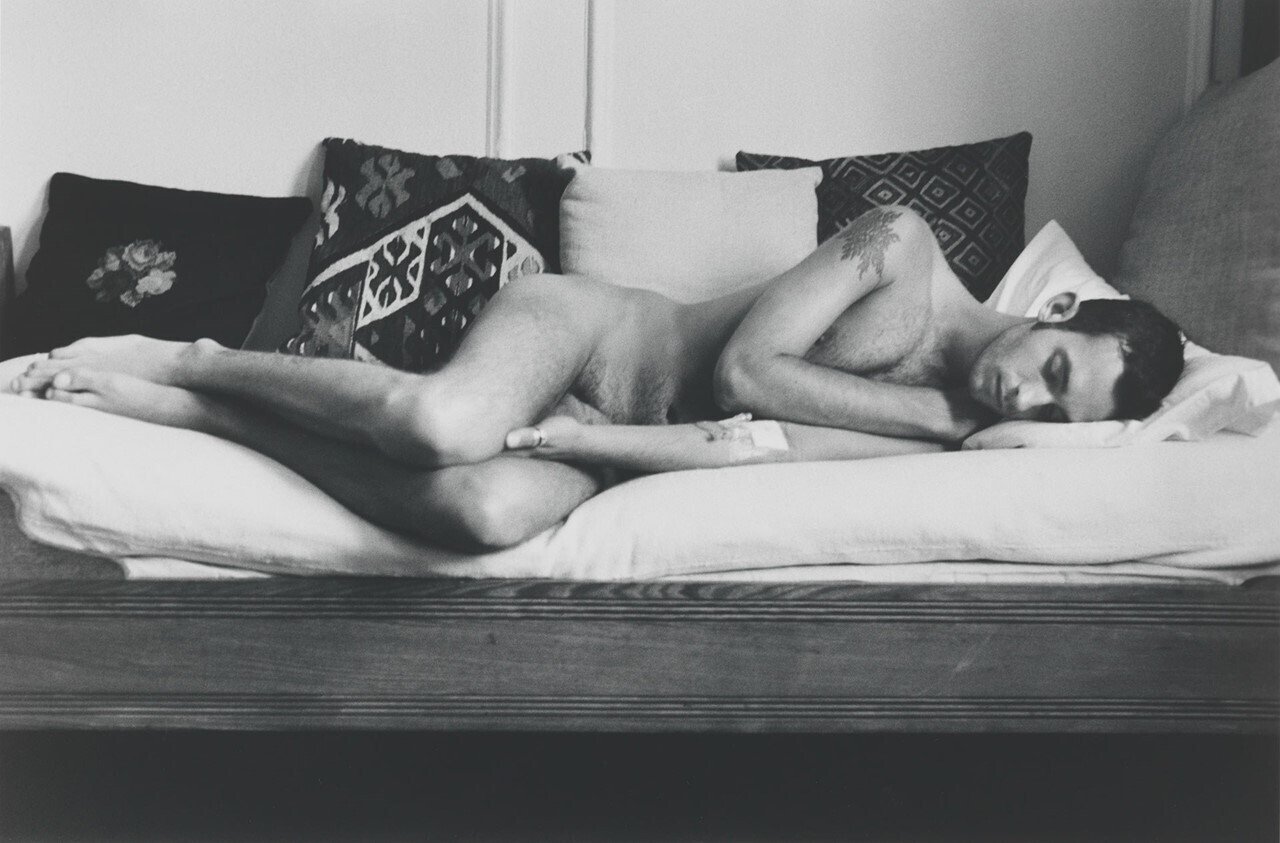Fotografía en blanco y negro de un chico tumbado sobre una cama