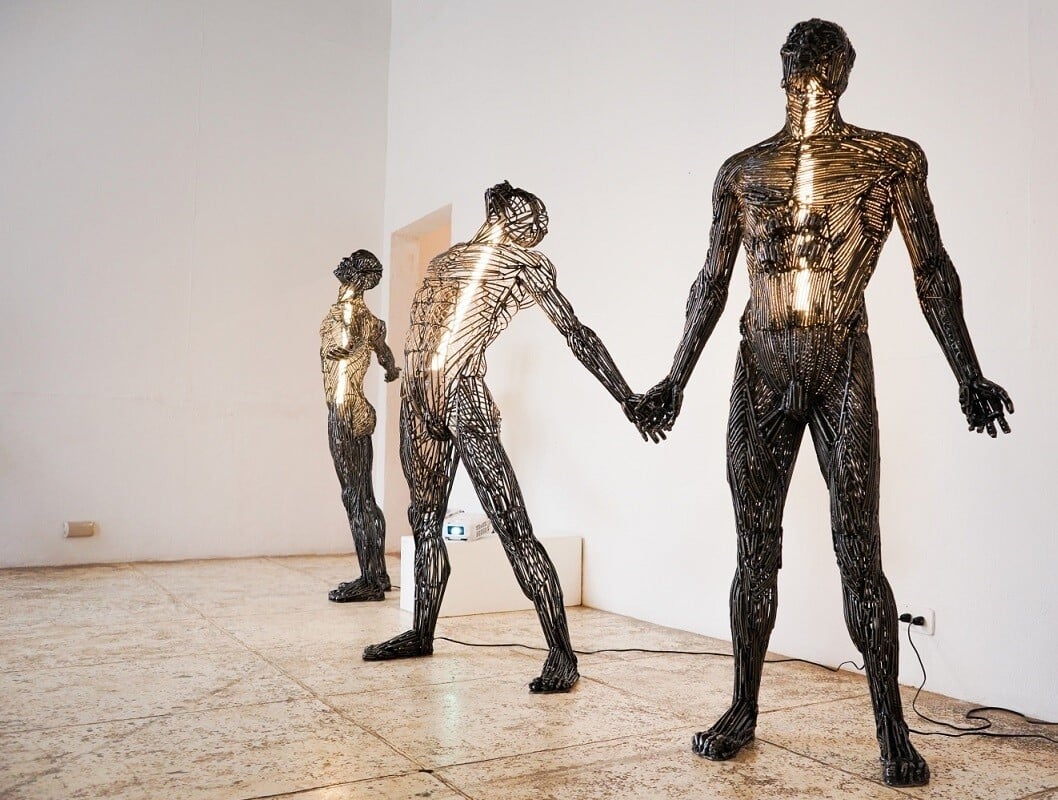 escultura metálica con luz en su interior que representa a una figura humana y es de tamaño real