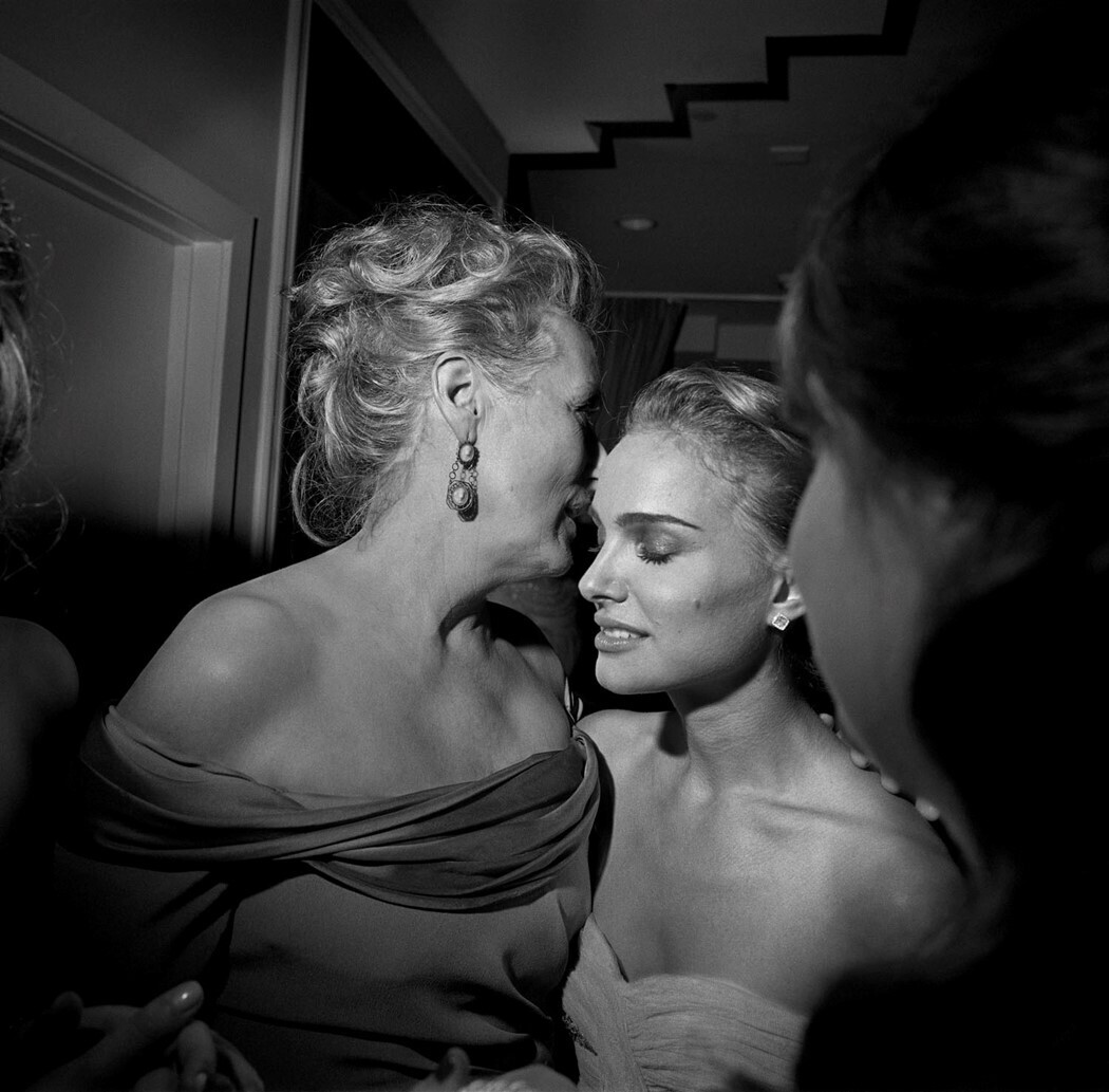 La actriz Meryl Styreep le cuenta algo al oído a la también actriz Natalie Portman en una fiesta