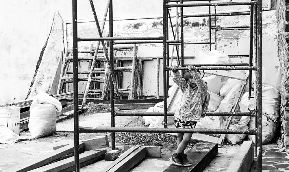 Niña jugando en andamios