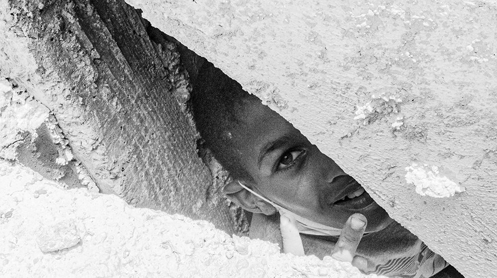 Niño asomándose entre las rocas