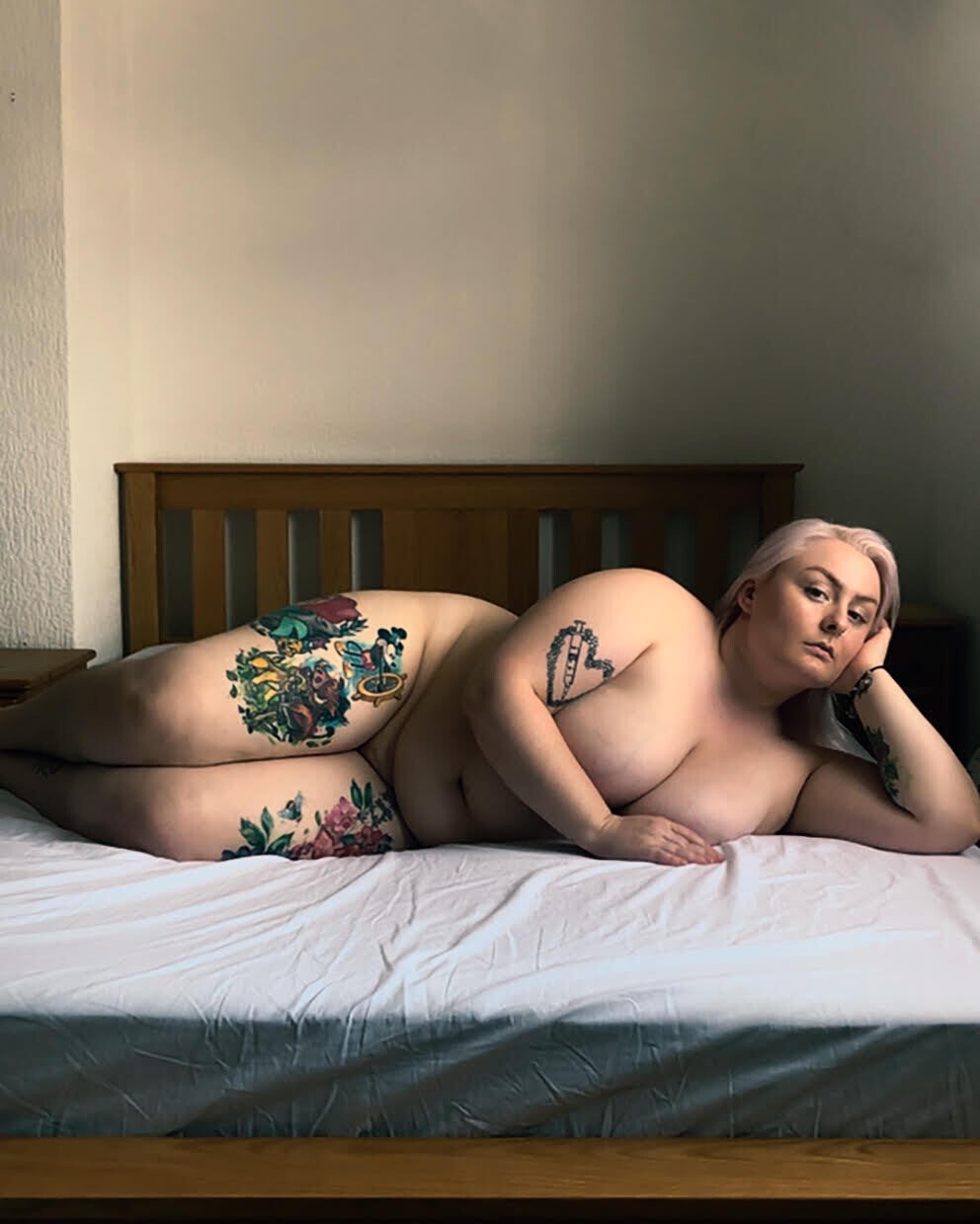 Fotografía de una mujer desnuda tumbada sobre su cama