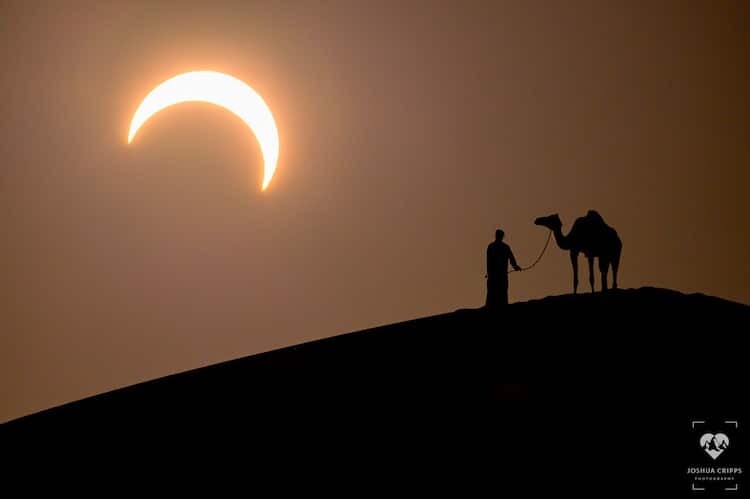 un eclipse solar enmarca a un hombre y a su camello en una espectacular fotografía de joshua cripps 5