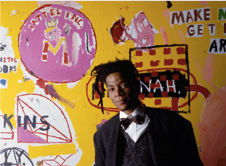 Jean Michel Basquiat con uno de sus cuadros