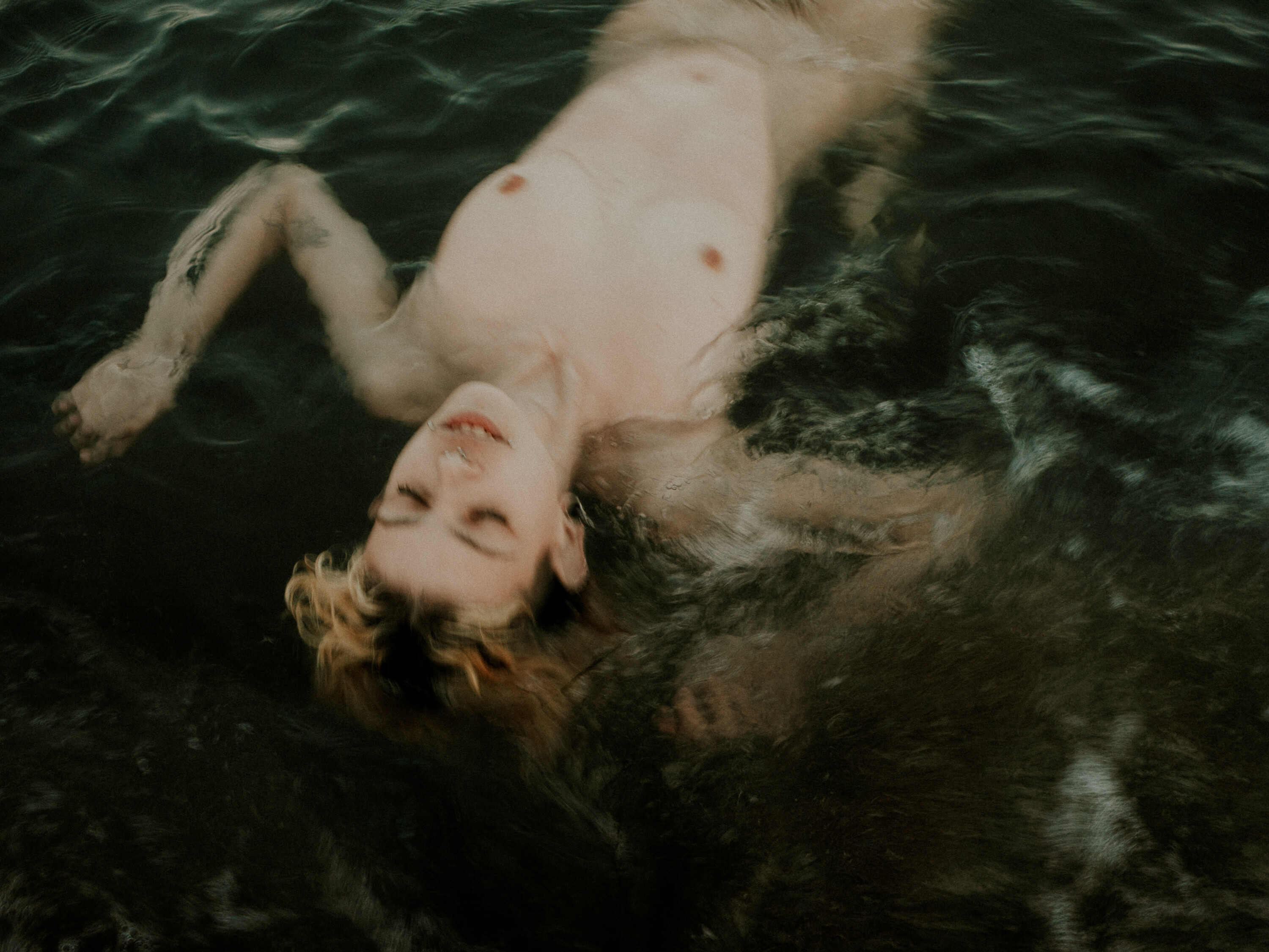 Una chica en el mar bañándose desnuda.