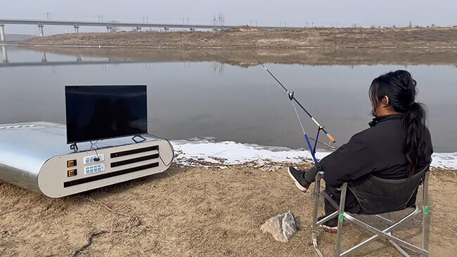 Viendo la televisión en la playa, cargando en el banco de energía