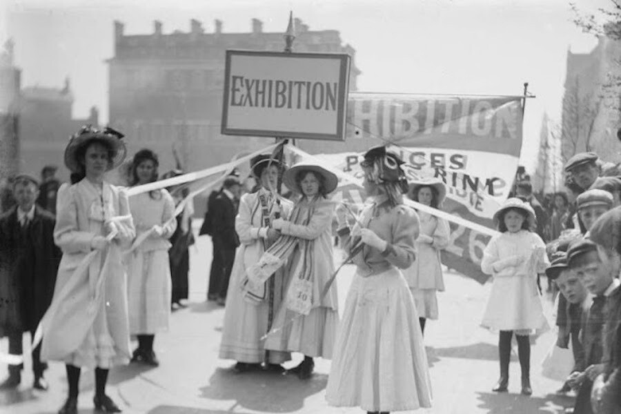 Jóvenes sufragistas promocionando la "Women's Exhibition" organizada por la Women's Social and Political Union (WSPU). Fotografía de Christina Broom.