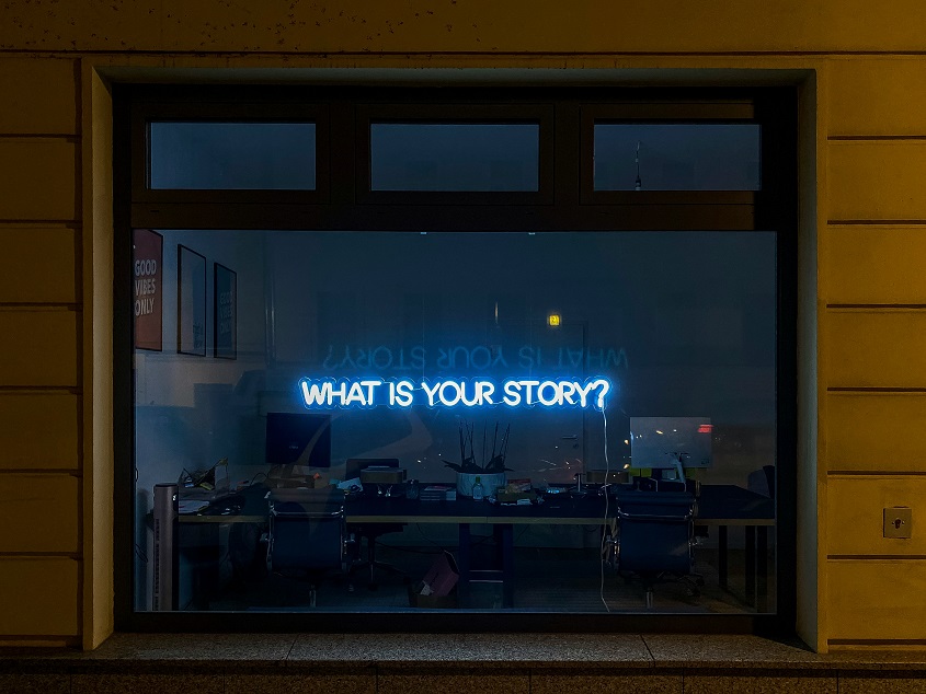 Un escaparate con unas letras en neón que dice What Is Your Story?
