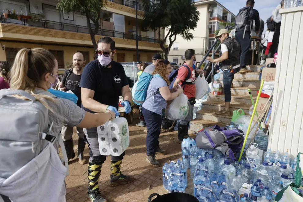 Varios voluntarios ayudando a transportar material en una cadena humana.