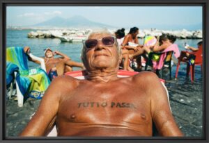 Un hombre mayor con un tatuaje en el pecho tomando el sol, fotografía de Robbie McIntosh